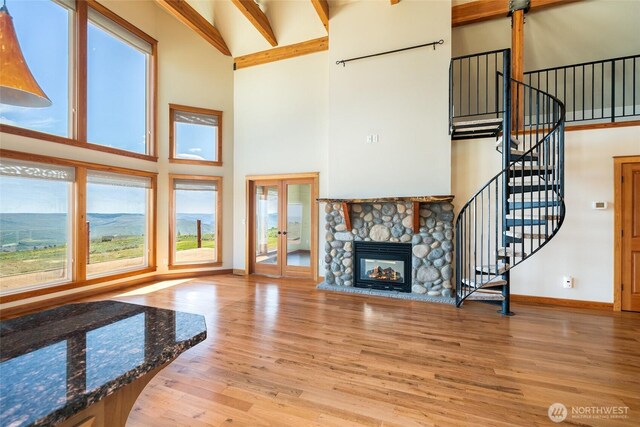 27 Scenic Dr, Brewster, WA 98812 - unfurnished living room with a towering ceiling, baseboards, wood finished floors, french doors, and stairs