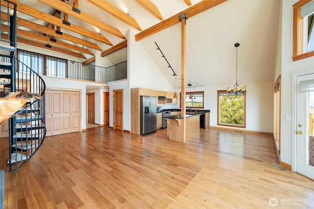 27 Scenic Dr, Brewster, WA 98812 - unfurnished living room with high vaulted ceiling, a chandelier, stairway, light wood-style floors, and beam ceiling