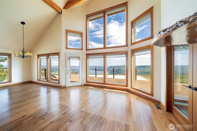 27 Scenic Dr, Brewster, WA 98812 - unfurnished living room with high vaulted ceiling, a chandelier, wood finished floors, baseboards, and beamed ceiling