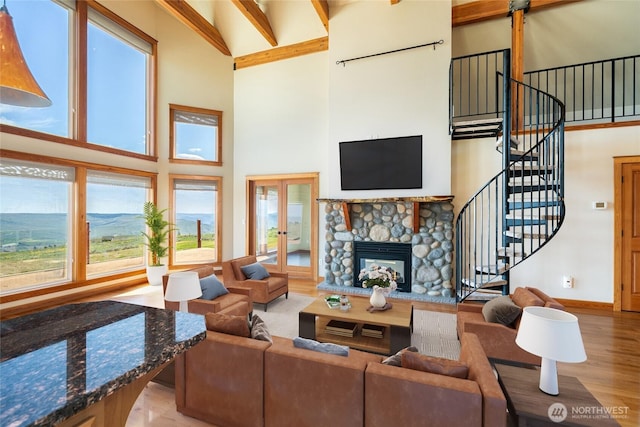 27 Scenic Dr, Brewster, WA 98812 - living area with a towering ceiling, wood finished floors, stairway, a stone fireplace, and french doors