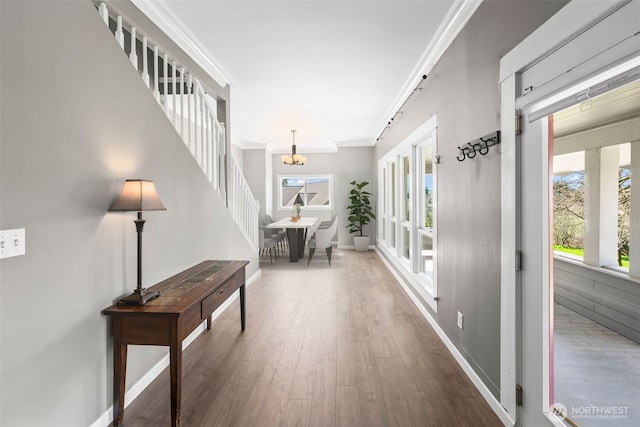 4723 Parker Rd E, Sumner, WA 98390 - hallway with crown molding, a chandelier, wood finished floors, and baseboards
