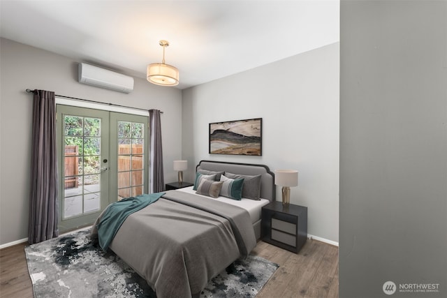 4723 Parker Rd E, Sumner, WA 98390 - bedroom with an AC wall unit, baseboards, french doors, and wood finished floors