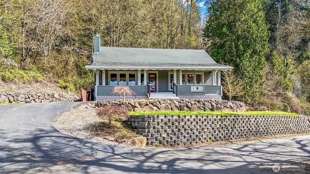 4723 Parker Rd E, Sumner, WA 98390 - view of front facade featuring a chimney, a porch, a forest view, and aphalt driveway