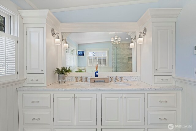 3119 108th Ave SE, Bellevue, WA 98004 - bathroom featuring double vanity, a shower stall, a chandelier, ornamental molding, and wainscoting