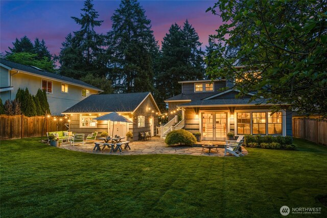 3119 108th Ave SE, Bellevue, WA 98004 - back of house at dusk featuring a fire pit, a patio area, and an outdoor structure