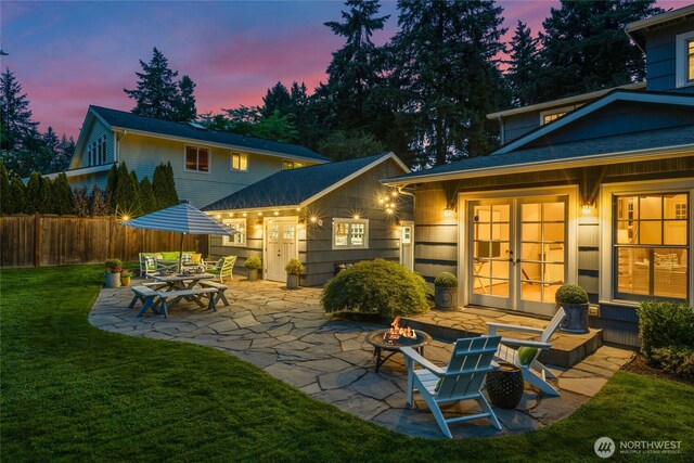 3119 108th Ave SE, Bellevue, WA 98004 - back of house at dusk with french doors, a patio area, and an outdoor fire pit
