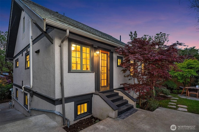 property entrance featuring fence and stucco siding
