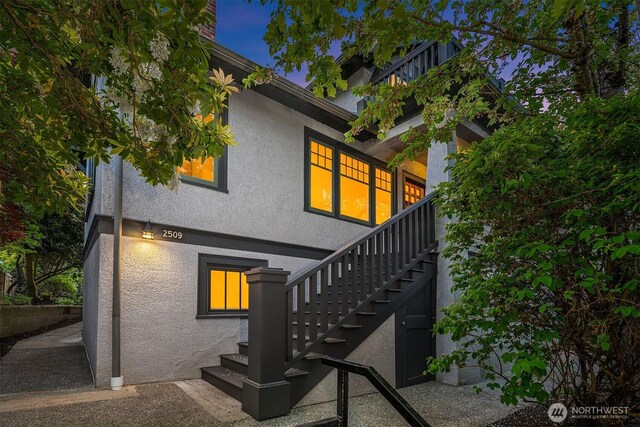 back of property featuring stairway and stucco siding