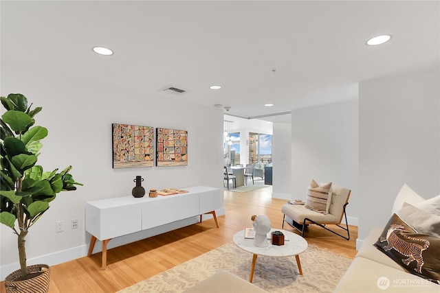living area with visible vents, light wood-type flooring, and recessed lighting