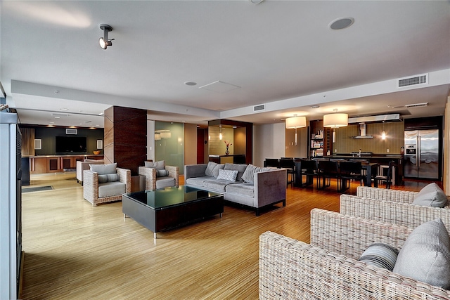 living area featuring light wood-style floors and visible vents