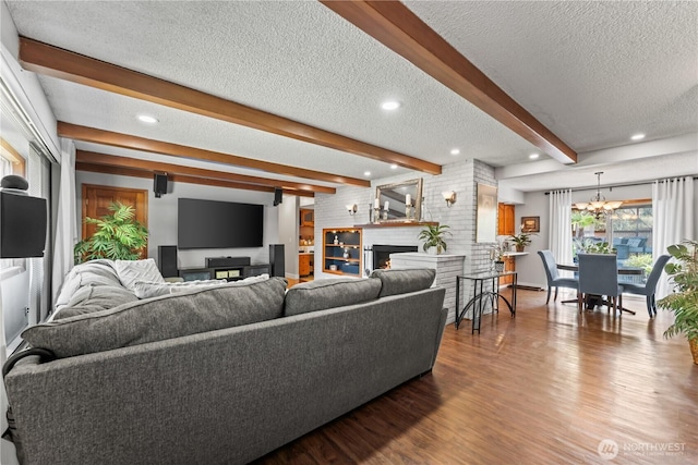 9811 NE 152nd Ave, Vancouver, WA 98682 - living area with wood finished floors, a textured ceiling, a chandelier, a large fireplace, and beamed ceiling