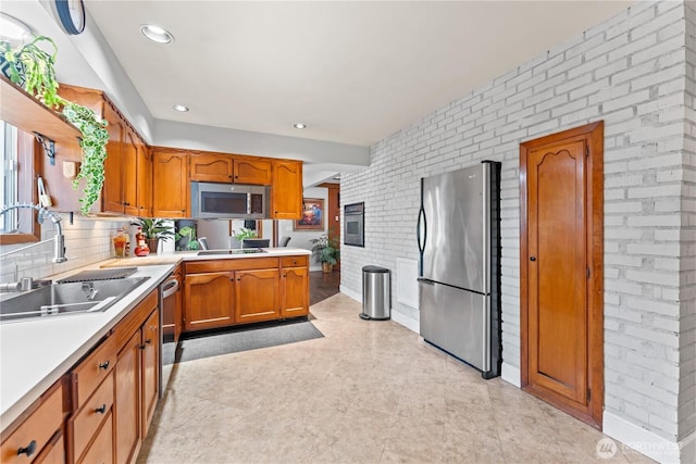 9811 NE 152nd Ave, Vancouver, WA 98682 - kitchen with brown cabinets, stainless steel appliances, light countertops, a sink, and brick wall