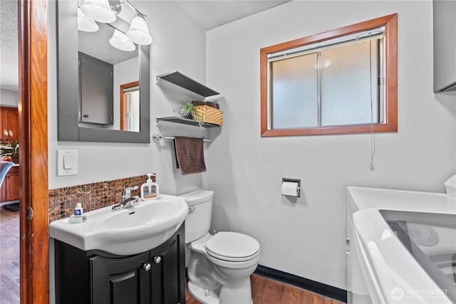 9811 NE 152nd Ave, Vancouver, WA 98682 - bathroom featuring toilet, baseboards, separate washer and dryer, wood finished floors, and vanity