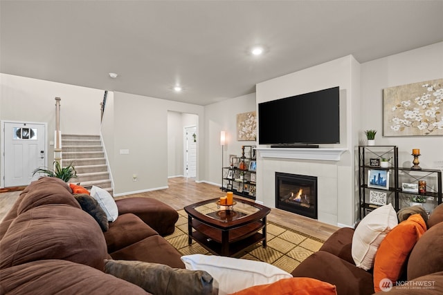 32832 SE Stevens St, Black Diamond, WA 98010 - living room featuring baseboards, a tiled fireplace, light wood-style flooring, and stairway