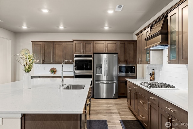 32832 SE Stevens St, Black Diamond, WA 98010 - kitchen with visible vents, dark brown cabinetry, custom range hood, a sink, and appliances with stainless steel finishes