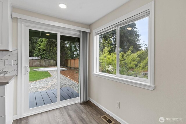 doorway featuring wood finished floors, baseboards, and recessed lighting