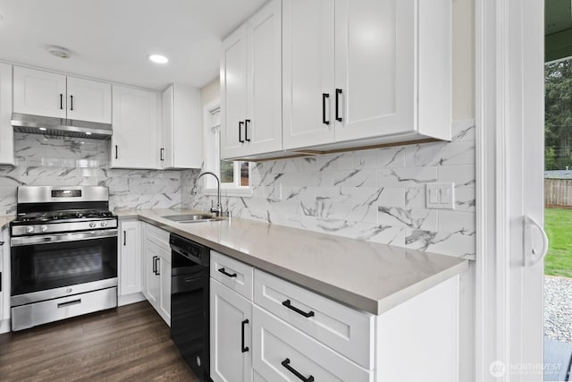 kitchen featuring stainless steel range with gas stovetop, a sink, black dishwasher, under cabinet range hood, and light countertops