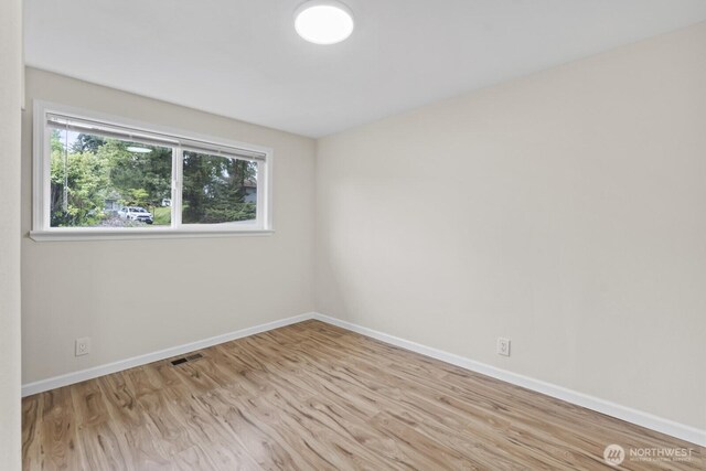 spare room with wood finished floors and baseboards