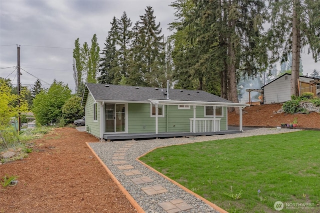 back of property with a wooden deck and a lawn