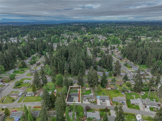 aerial overview of property's location with a forest, property boundaries highlighted, and nearby suburban area