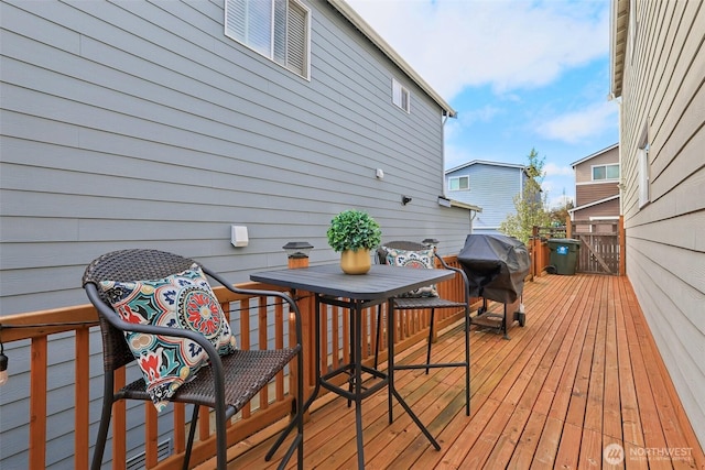 wooden terrace featuring outdoor dining space and area for grilling