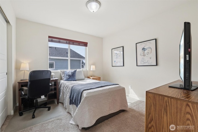 bedroom featuring light carpet and baseboards