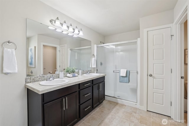 full bath featuring a sink, a shower stall, double vanity, and toilet