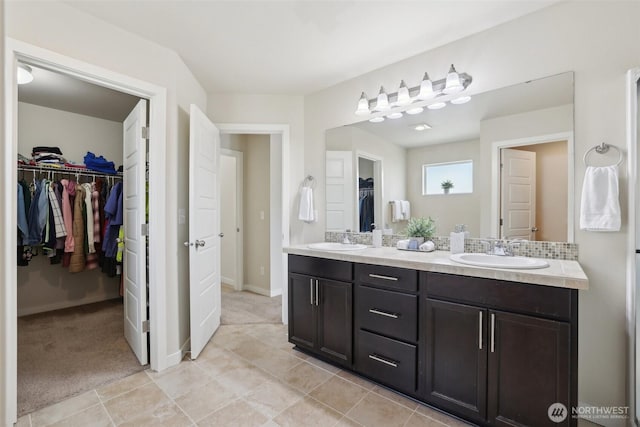 full bathroom featuring tile patterned floors, a sink, and double vanity