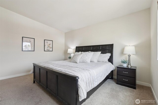 bedroom featuring baseboards and light carpet