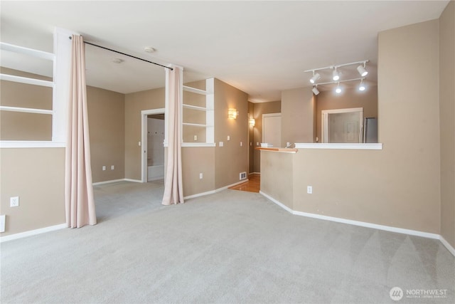 empty room with carpet floors, baseboards, and visible vents