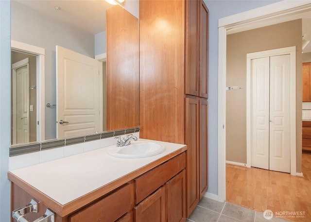 bathroom with vanity, baseboards, and tile patterned flooring