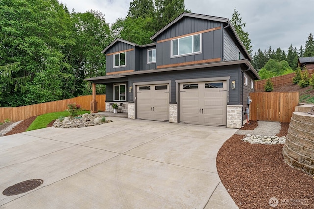 2302 S Royal Ct, Ridgefield, WA 98642 - modern home with stone siding, board and batten siding, an attached garage, concrete driveway, and a porch