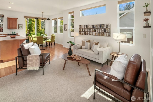 living area featuring baseboards, recessed lighting, and light wood-style flooring