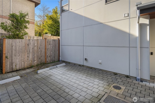 exterior space featuring a patio area, uncovered parking, and fence
