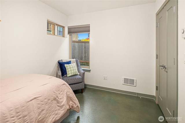 bedroom with visible vents, finished concrete flooring, and baseboards