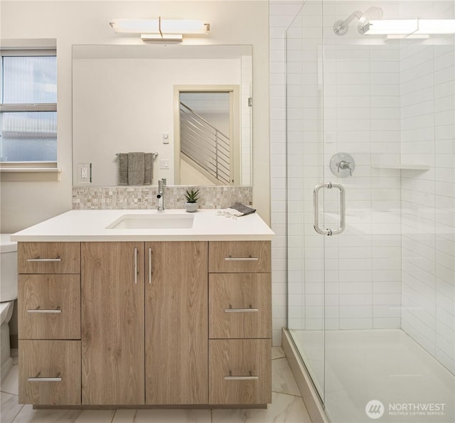 bathroom with vanity, marble finish floor, a shower stall, and toilet
