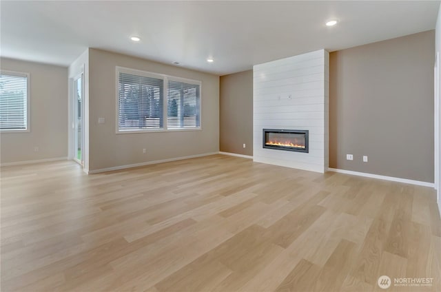 unfurnished living room with recessed lighting, light wood finished floors, visible vents, baseboards, and a large fireplace