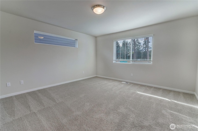 carpeted spare room featuring baseboards