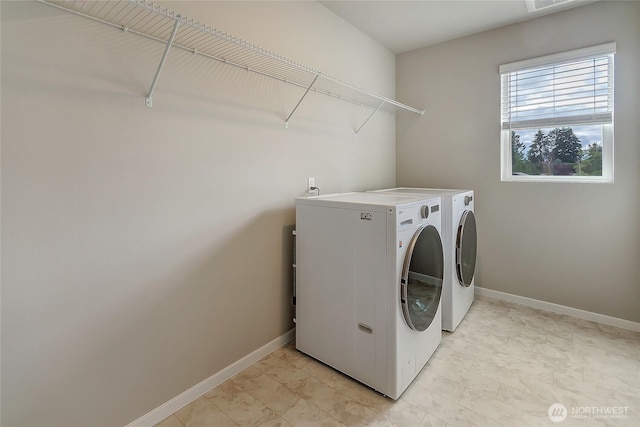 laundry room featuring washing machine and clothes dryer, laundry area, and baseboards