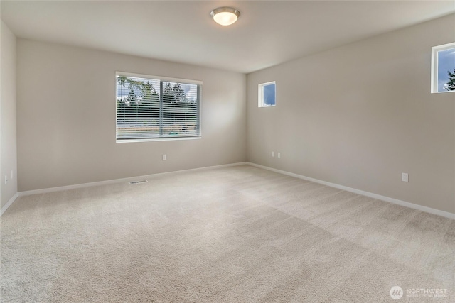 carpeted empty room with visible vents and baseboards
