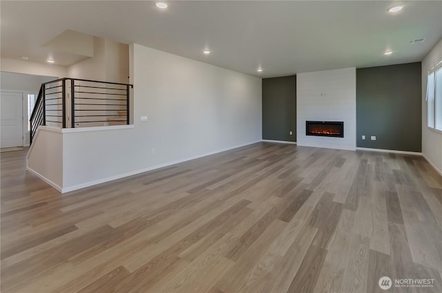 18213 35th Avenue Ct E, Tacoma, WA 98446 - unfurnished living room with light wood-type flooring, a large fireplace, recessed lighting, and stairs
