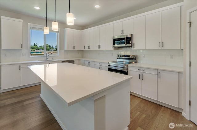 18213 35th Avenue Ct E, Tacoma, WA 98446 - kitchen featuring stainless steel appliances, wood finished floors, backsplash, white cabinets, and recessed lighting