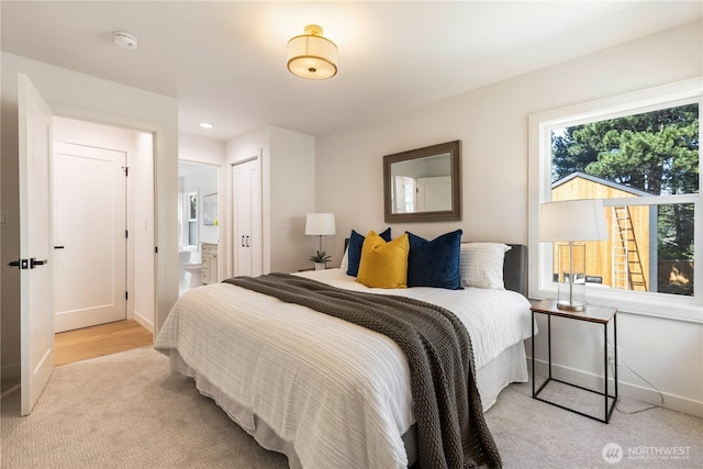 bedroom featuring light carpet, ensuite bath, baseboards, and recessed lighting