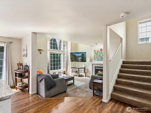 17581 110th Ln SE Unit 3, Renton, WA 98055 - living room featuring wood finished floors, stairway, a lit fireplace, and baseboards