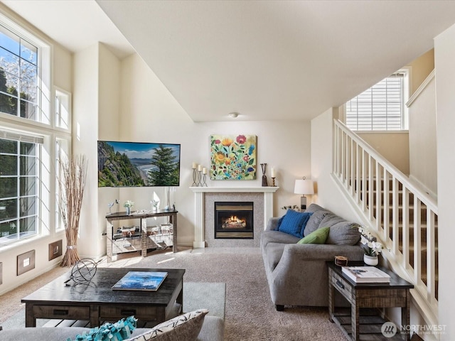 17581 110th Ln SE Unit 3, Renton, WA 98055 - carpeted living room featuring healthy amount of natural light, a lit fireplace, and stairs