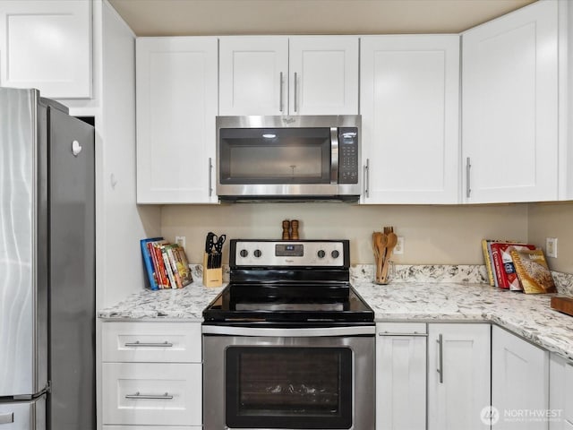 17581 110th Ln SE Unit 3, Renton, WA 98055 - kitchen featuring appliances with stainless steel finishes, white cabinetry, and light stone counters