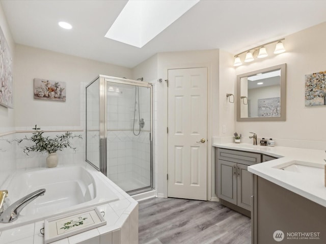 17581 110th Ln SE Unit 3, Renton, WA 98055 - full bathroom with a skylight, a stall shower, a bath, vanity, and wood finished floors