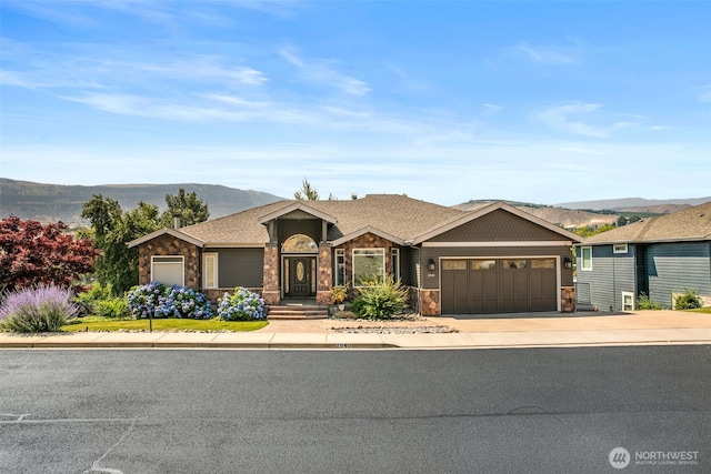2840 Mikayla Ln, East Wenatchee, WA 98802 - ranch-style home with an attached garage, stone siding, a mountain view, and driveway