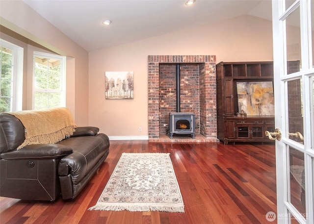 living area with vaulted ceiling, recessed lighting, a wood stove, and dark wood finished floors