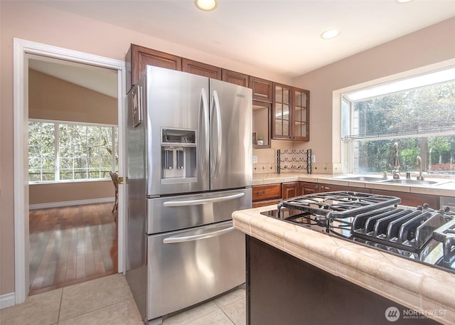 kitchen featuring plenty of natural light, recessed lighting, a sink, and stainless steel fridge